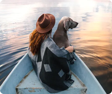 Un propriétaire d’animal de compagnie dans un bateau avec son chien qui cherche à savoir combien coûte l’assurance pour animaux de compagnie par mois.