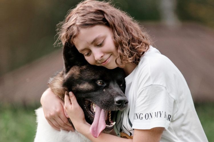 Woman hugging happy dog outdoors